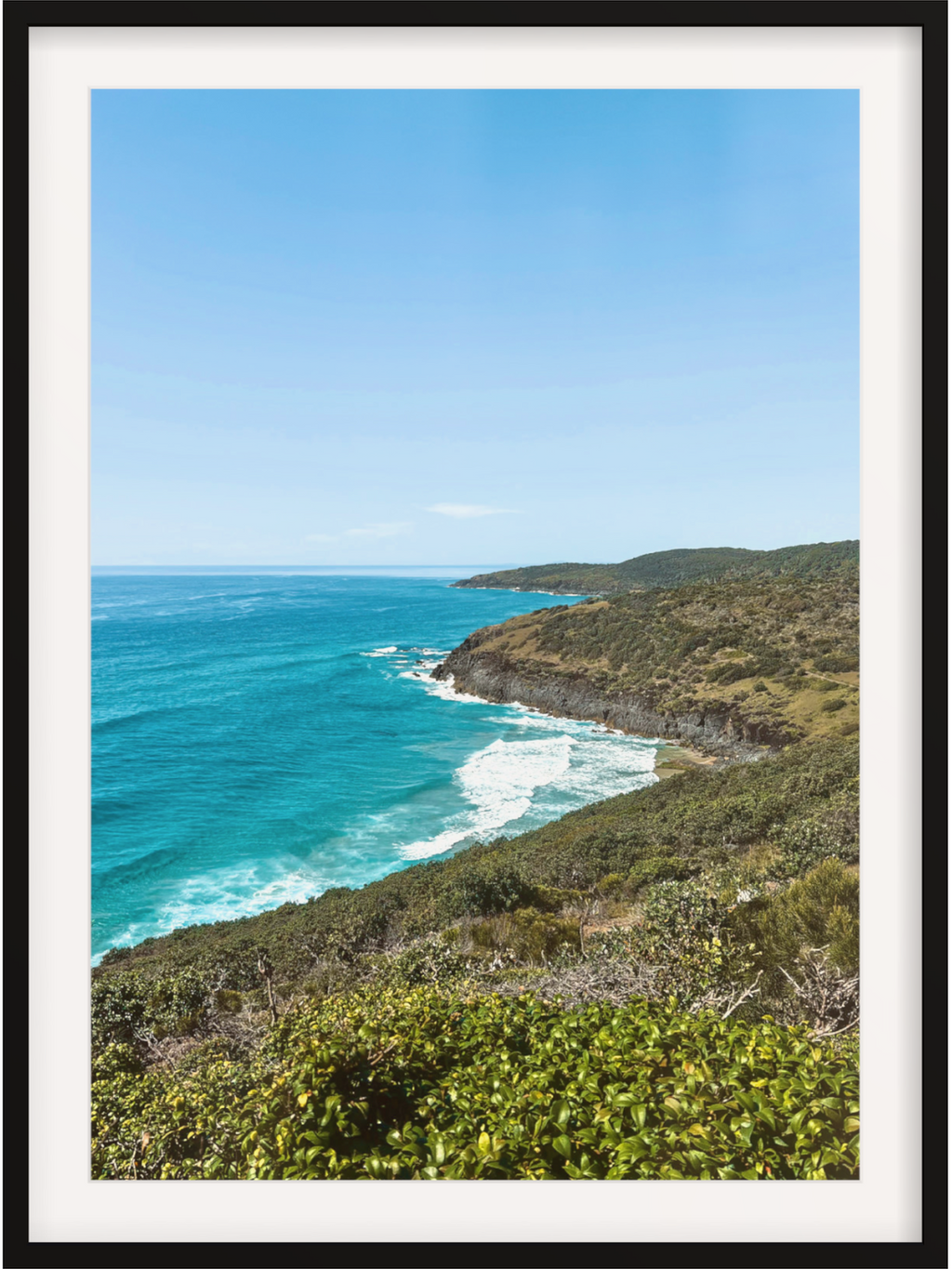 Hat Head Australia coastal print in black frame with white mat showing elevated view of ocean and headland
