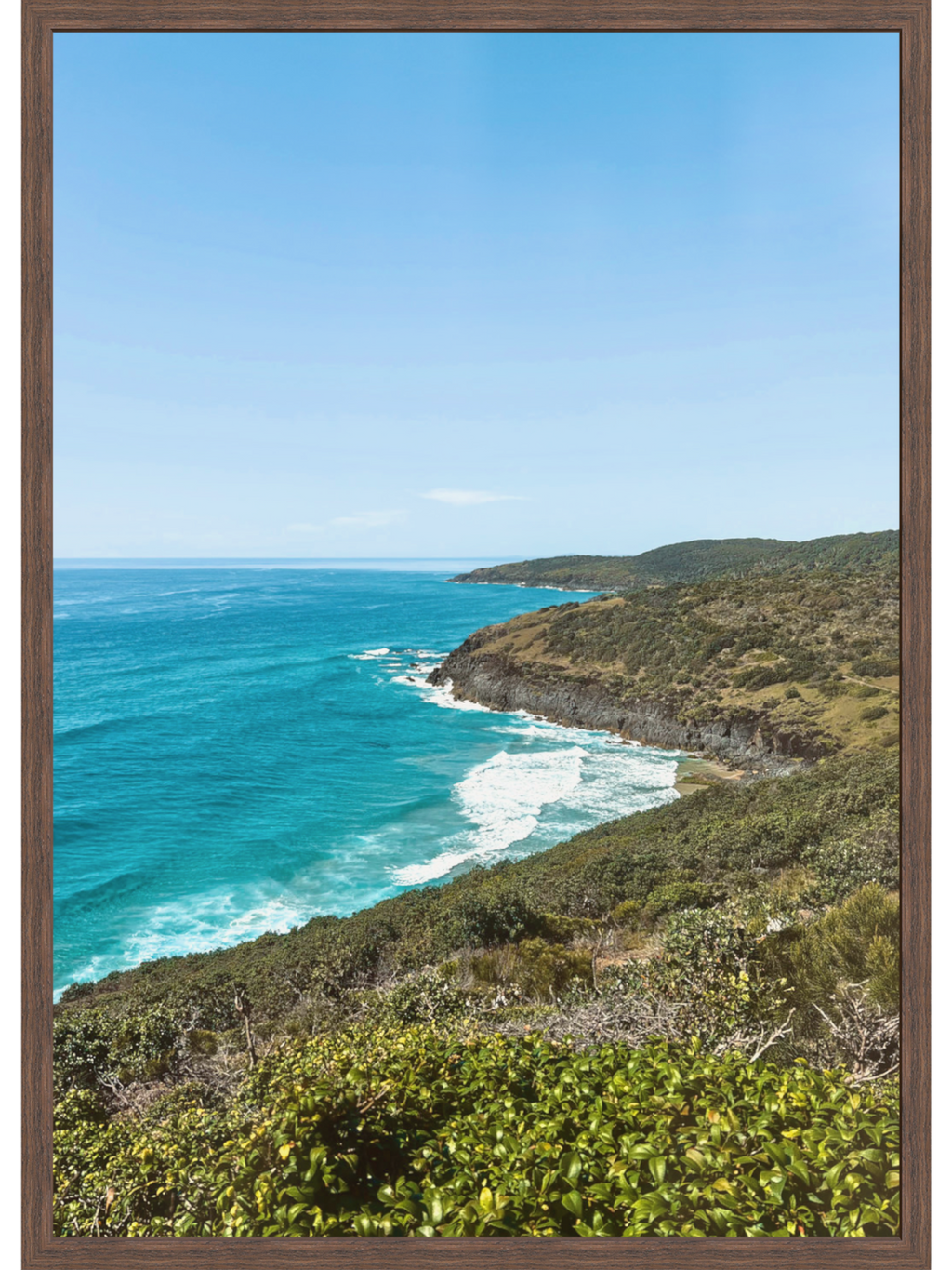 Hat Head Australia coastal landscape print in dark brown wood frame featuring turquoise water and green shrubs