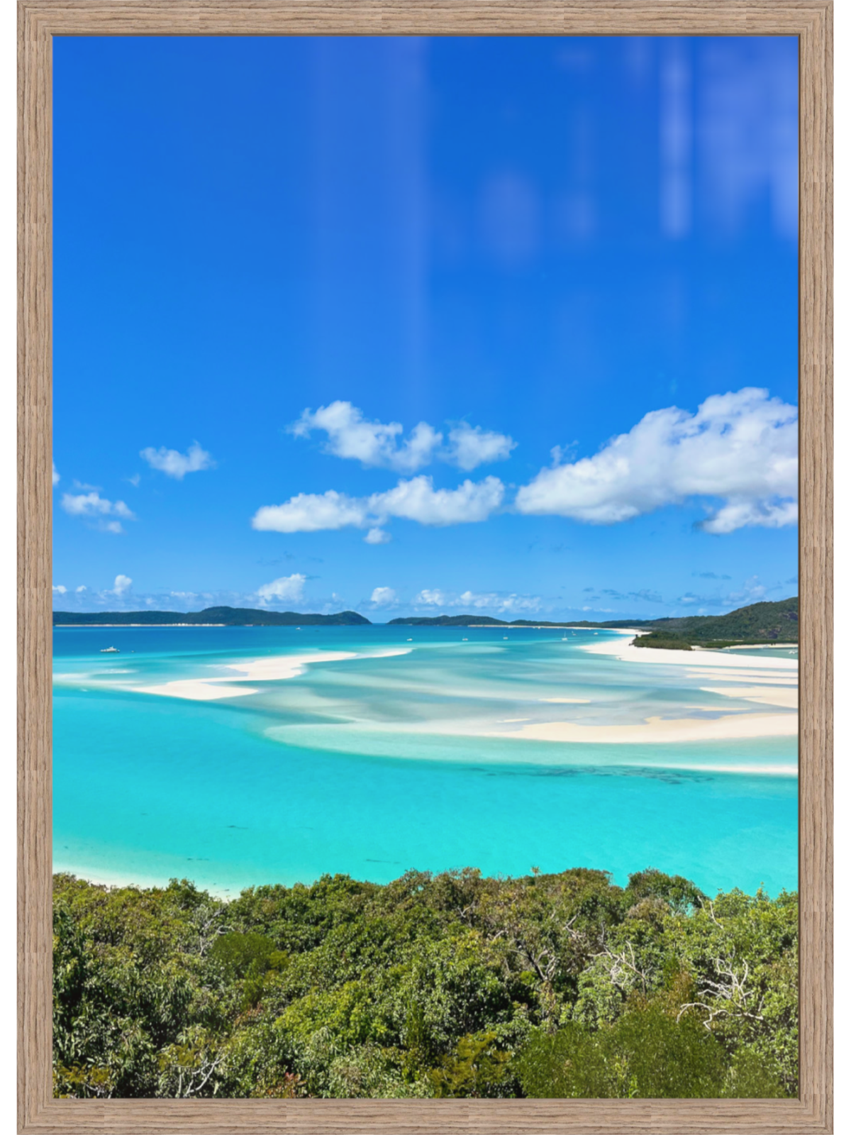 Beach scene with clear blue water and sky, framed in brown.