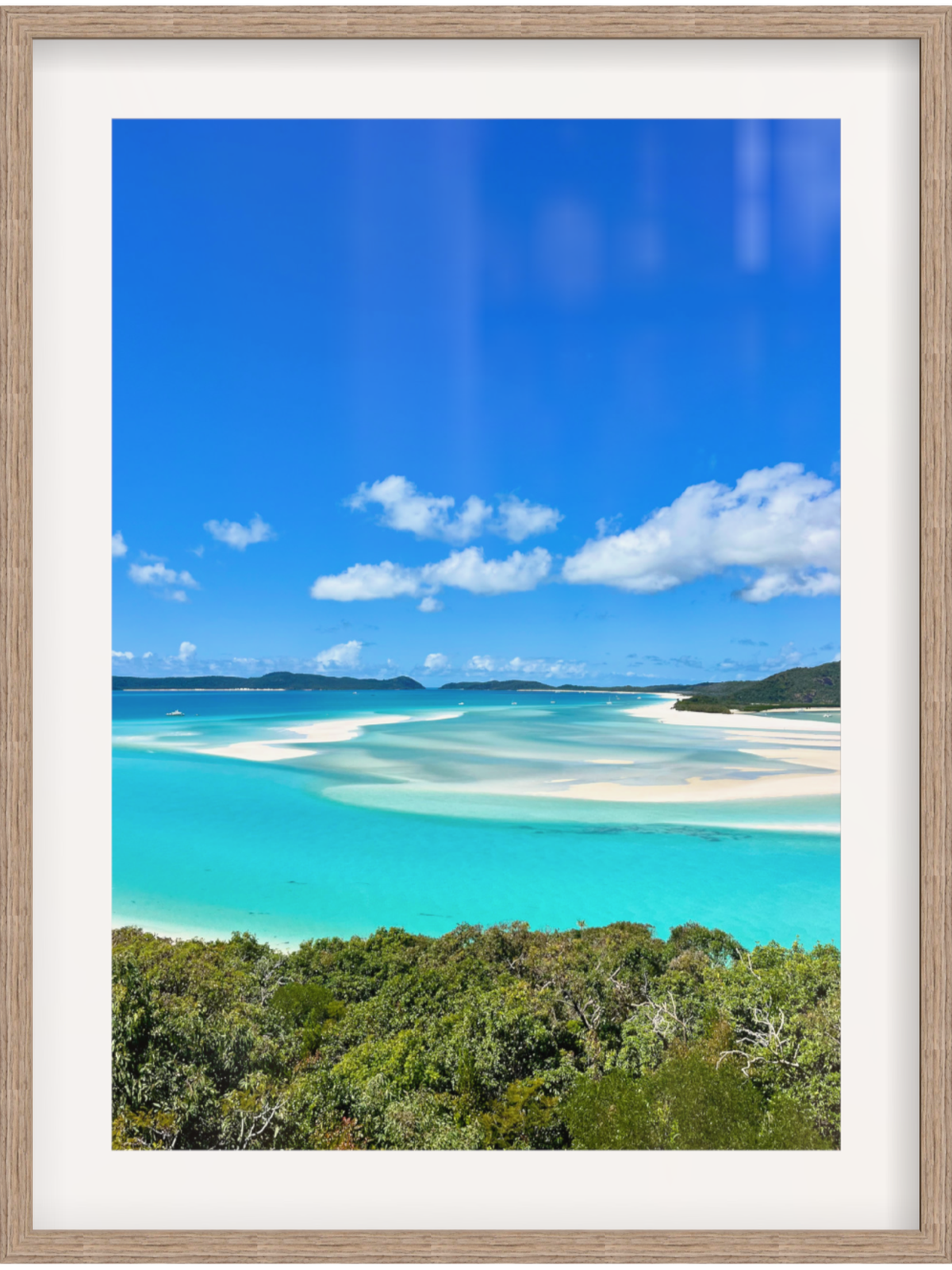 Framed photograph of a tropical beach with turquoise water and blue sky.