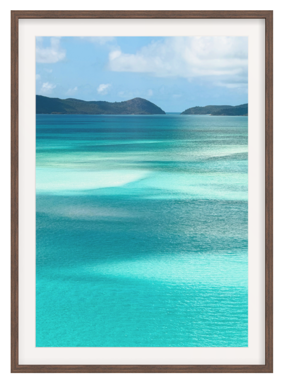 Scenic view of turquoise ocean water with shallow clear pools, distant dark green hills, and a blue sky with white clouds. choc frame