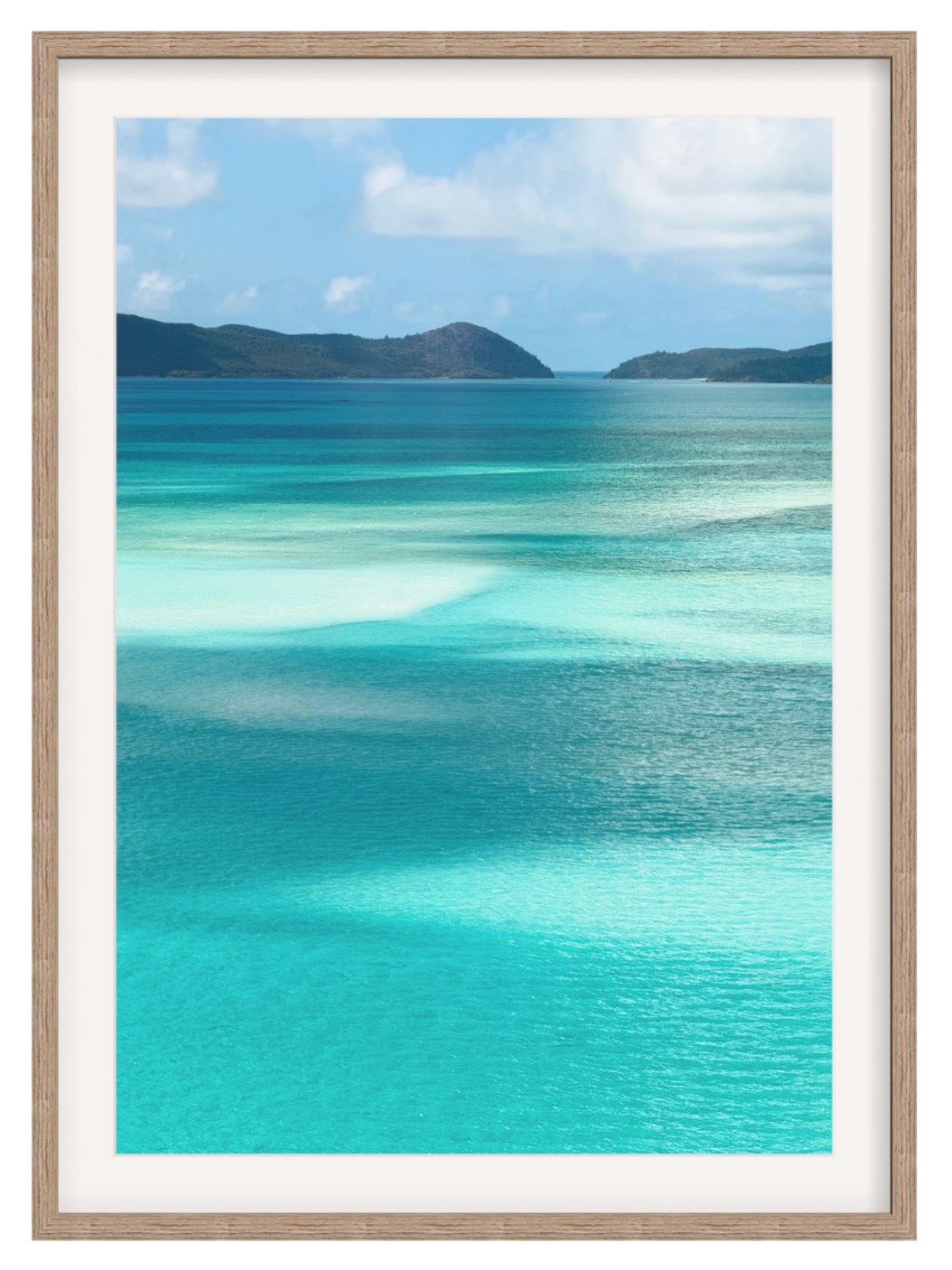 Scenic view of turquoise ocean water with shallow clear pools, distant dark green hills, and a blue sky with white clouds. hazel frame