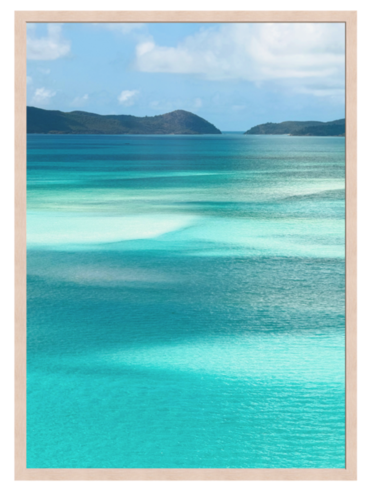 Scenic view of turquoise ocean water with shallow clear pools, distant dark green hills, and a blue sky with white clouds.light oak frame