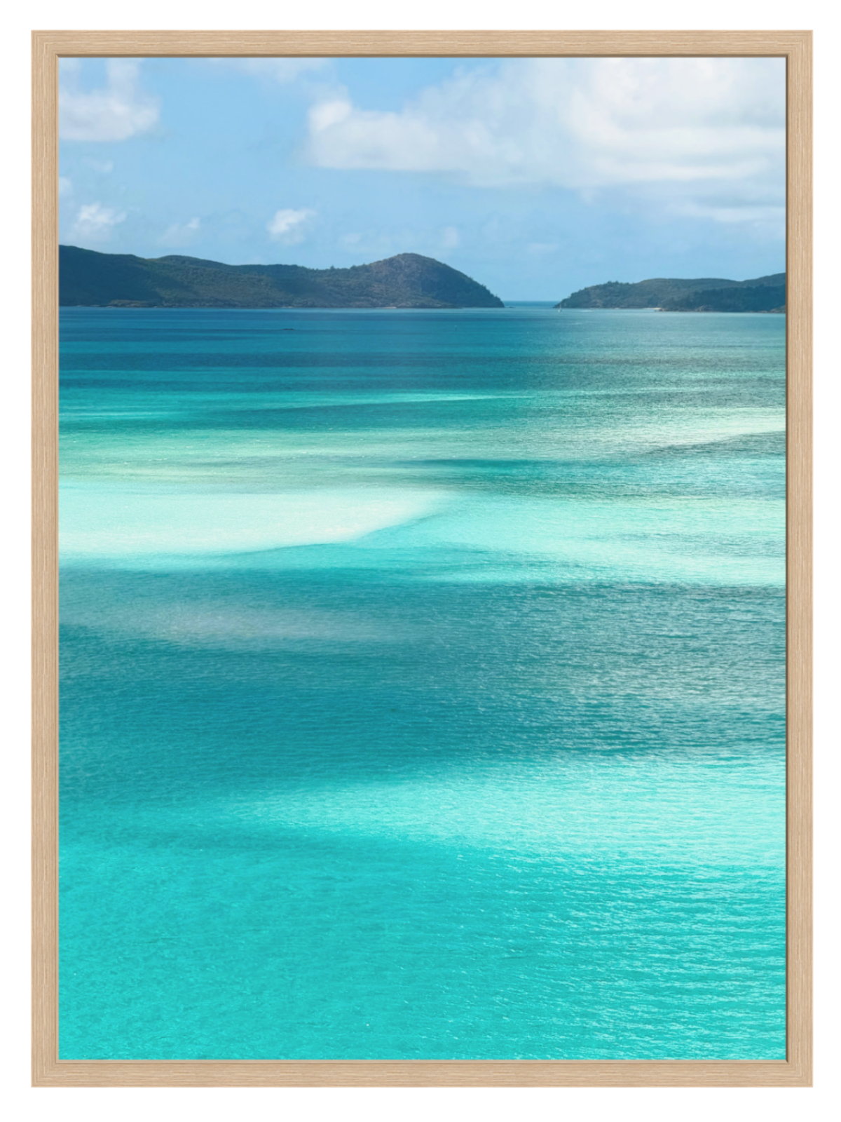 Scenic view of turquoise ocean water with shallow clear pools, distant dark green hills, and a blue sky with white clouds. oak frame