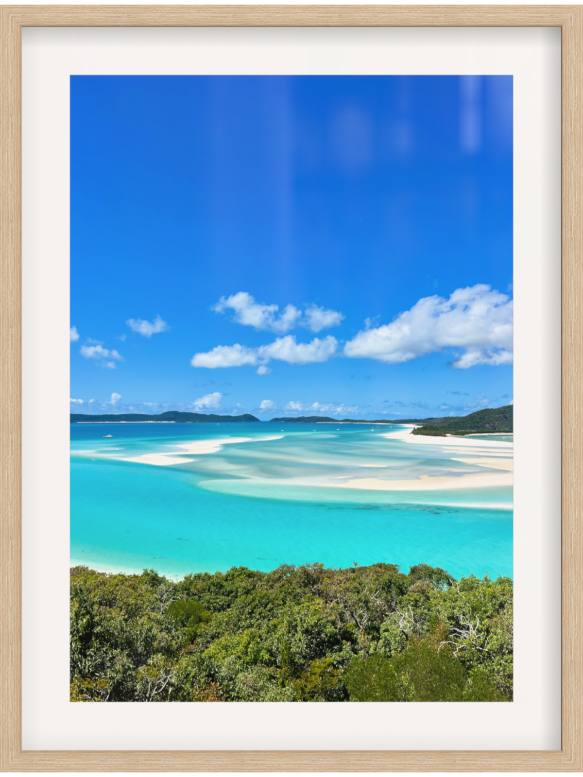 Framed photograph of a tropical beach with clear blue water and white sand.