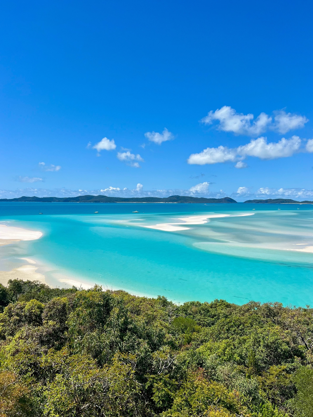 Scenic view of a tropical island with clear blue water and white sand.