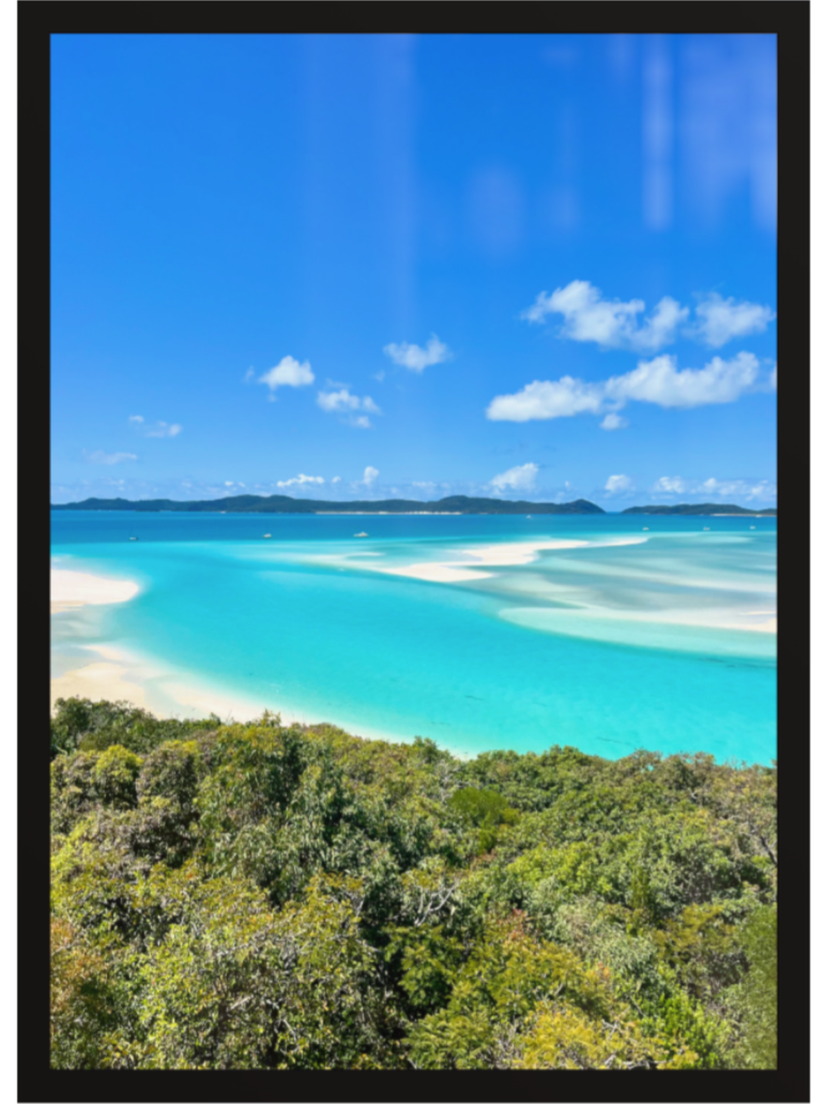 Scenic view of a tropical beach with turquoise water and white sand, framed by a black border.