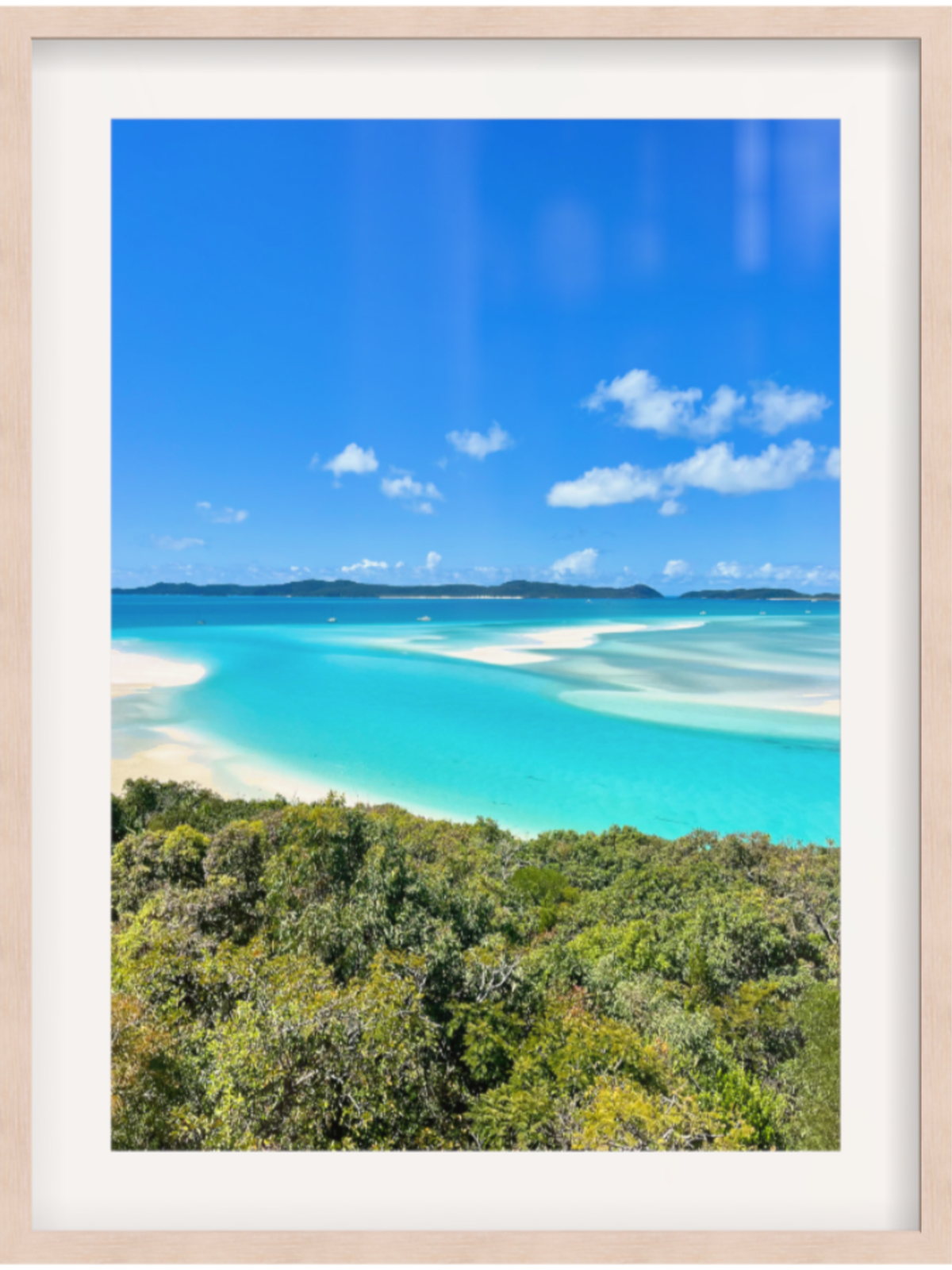 Framed photograph of a tropical beach with turquoise water and blue sky.
