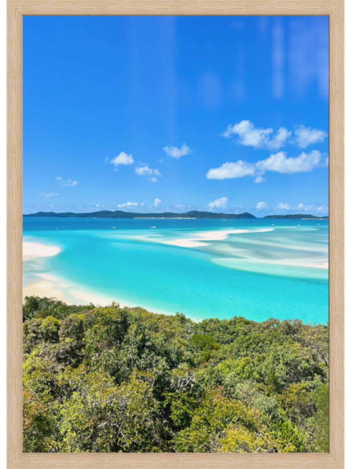 Framed artwork of a tropical beach with turquoise water and blue sky.