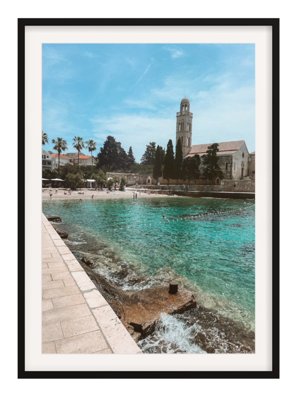 Framed photograph of a coastal scene with a church and beach.
