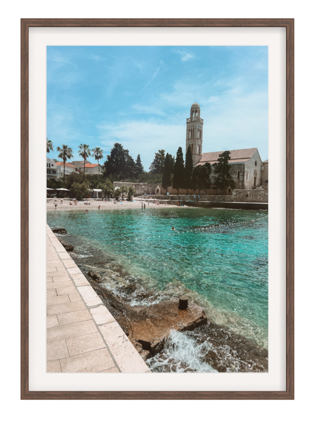 Framed photograph of a coastal scene with a church and clear blue water.
