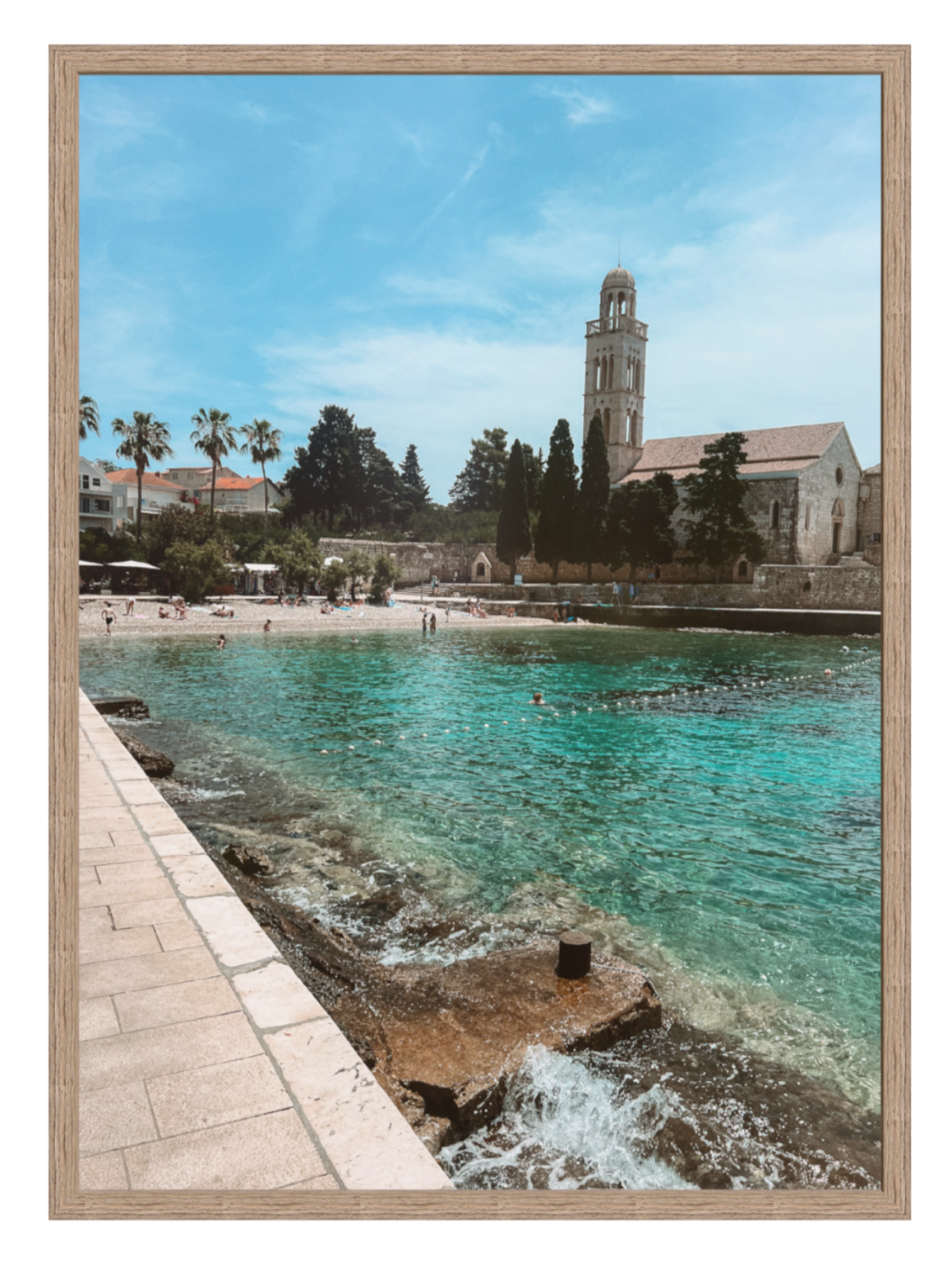 Framed photograph of a coastal scene with a church and clear blue water.