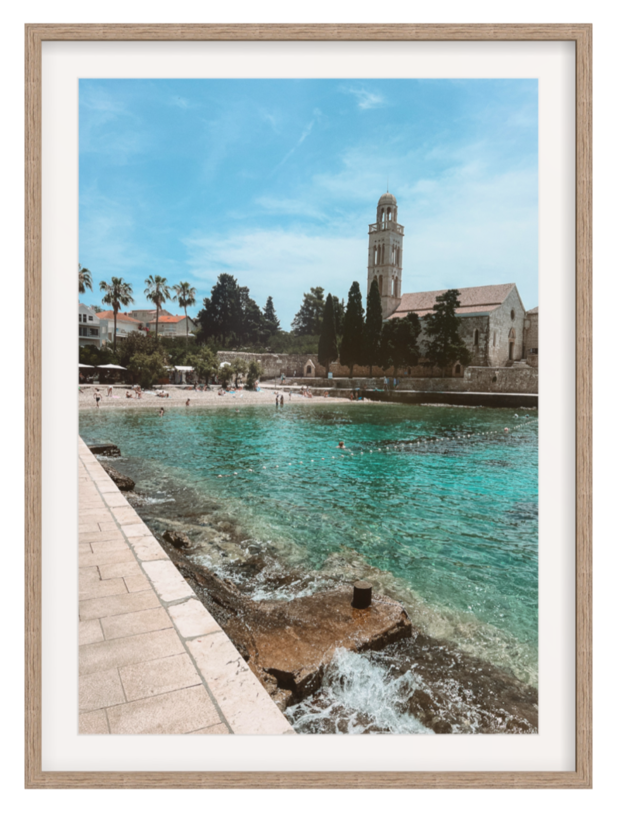 Framed photograph of a coastal scene with a church and beach.