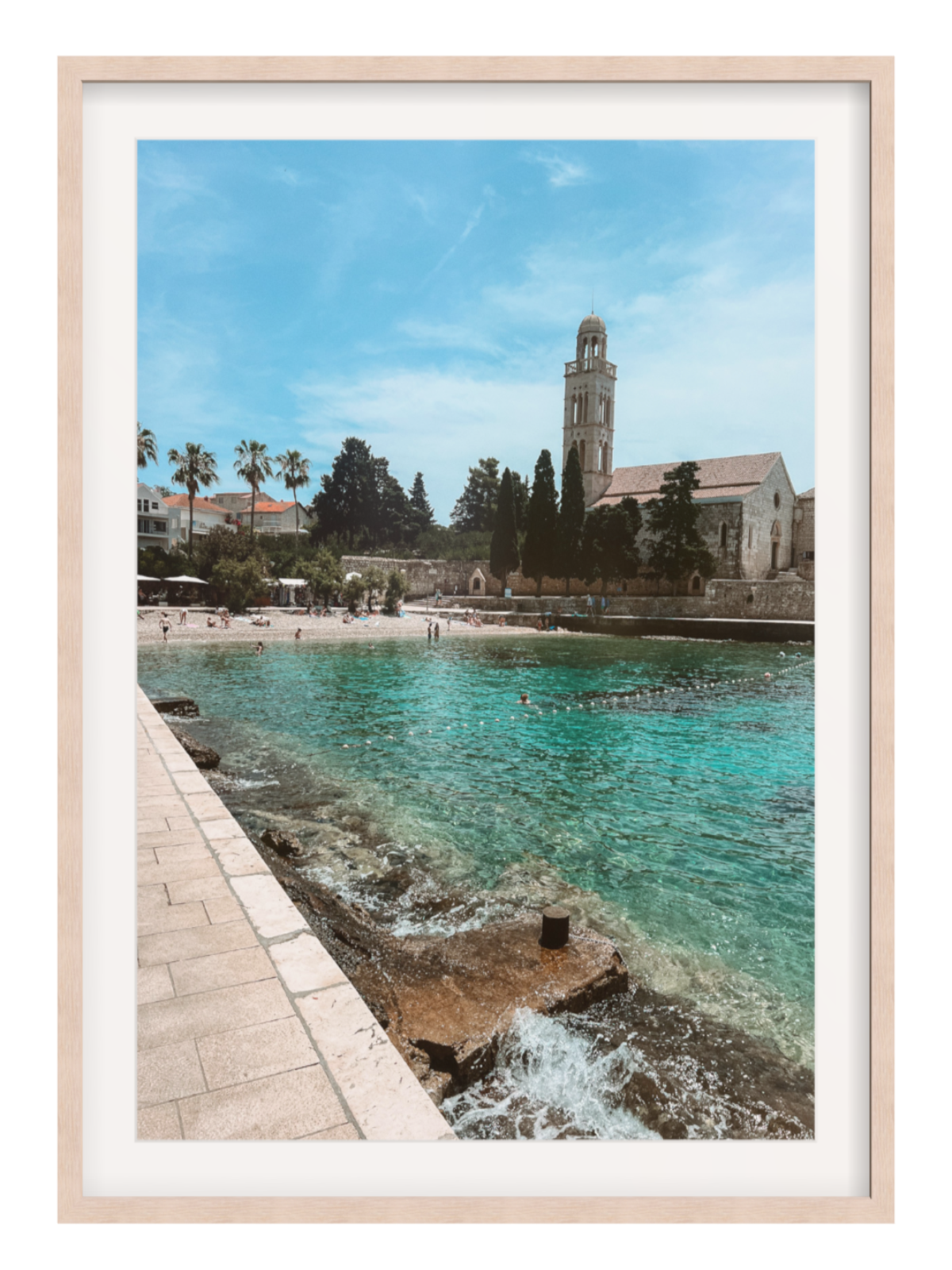 Framed photograph of a coastal scene with a church and beach.
