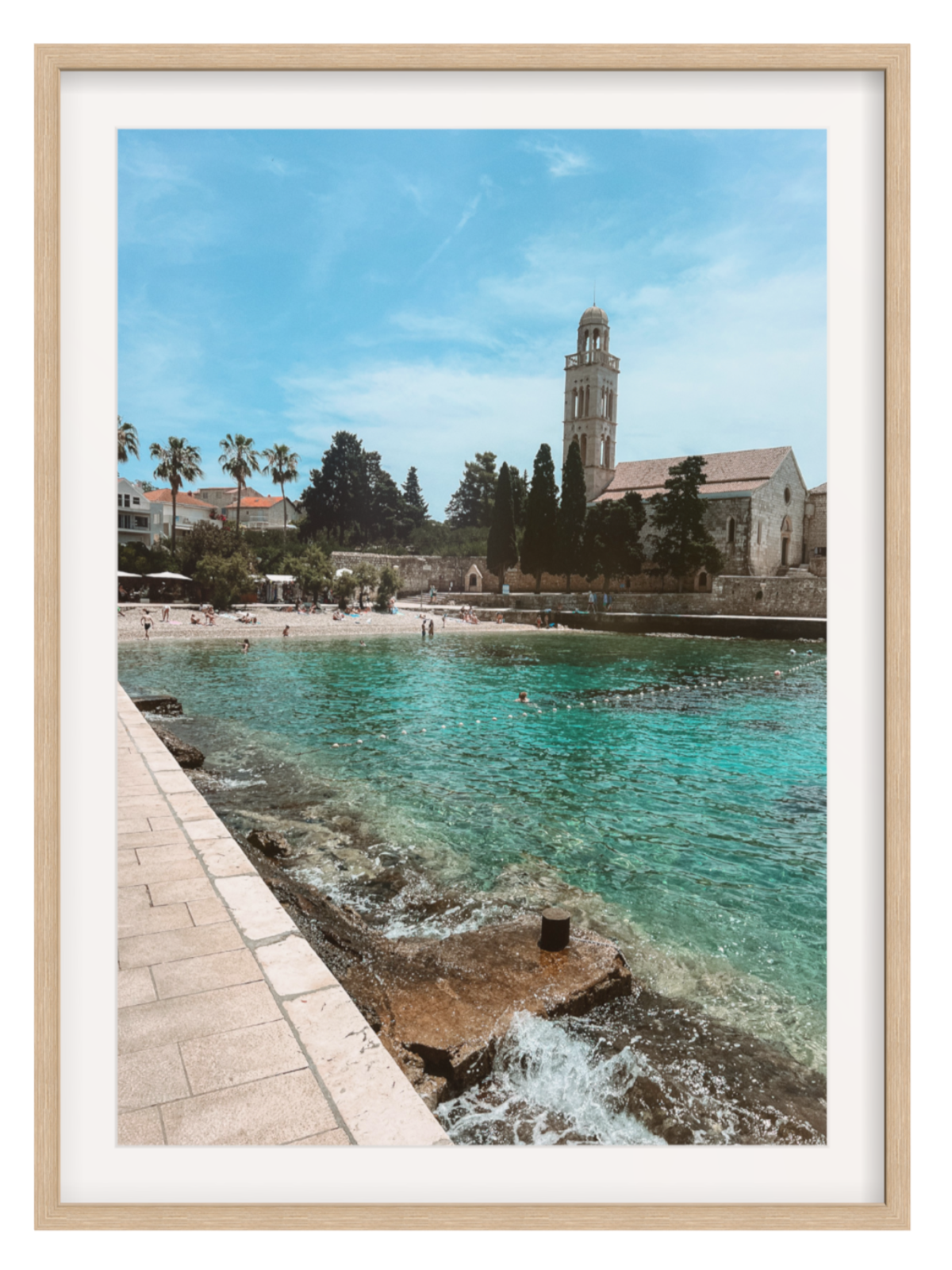 Framed photograph of a coastal scene with a church and beach.
