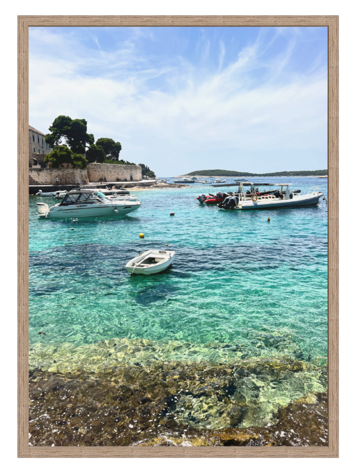 Coastal scene with boats in clear blue water, framed in a wooden manner.