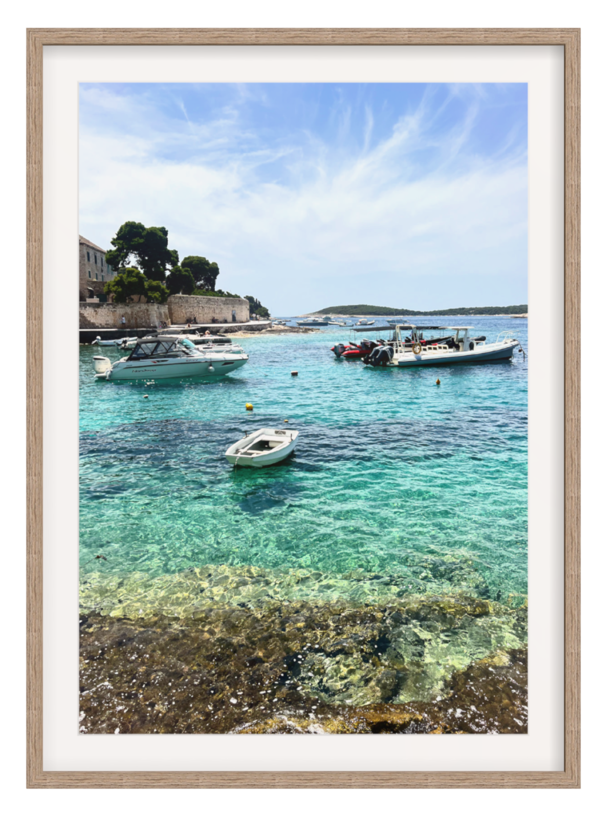 Framed photograph of a coastal scene with boats in clear water.
