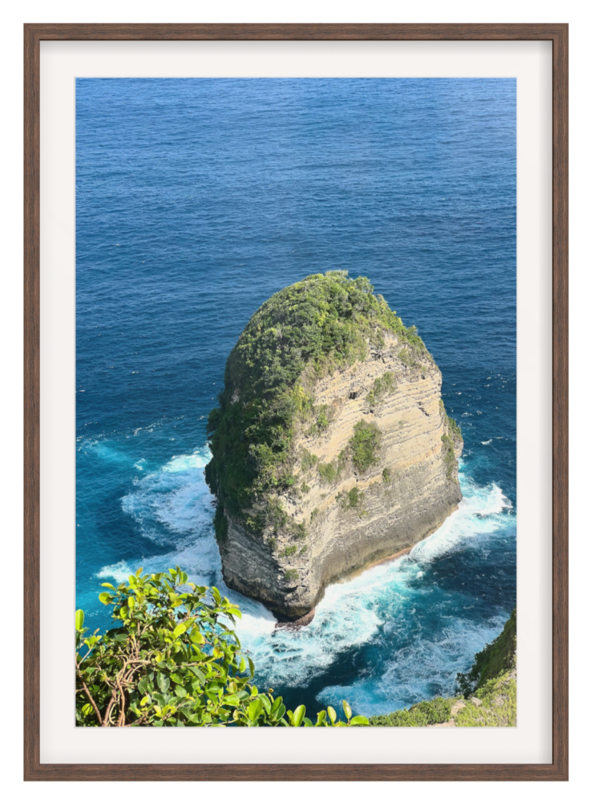 Chocolate Framed photograph of a rocky island with blue ocean and white waves.