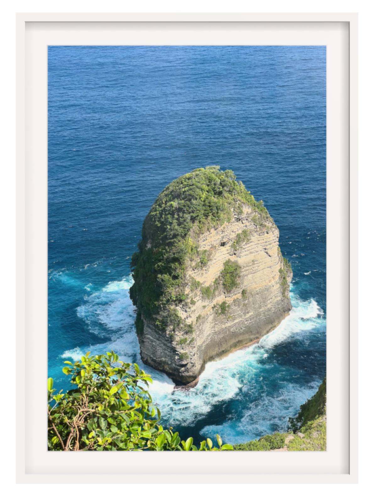 Isolated rock formation in the ocean with a white frame and border