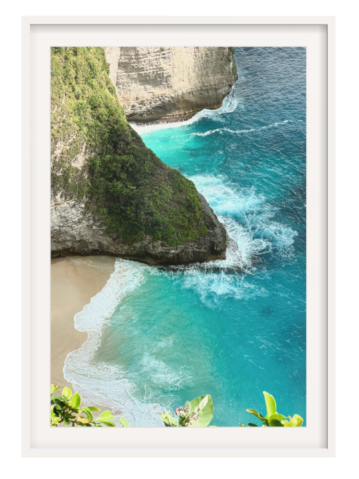 white Framed border photograph of a tropical beach with turquoise water and rocky cliffs.
