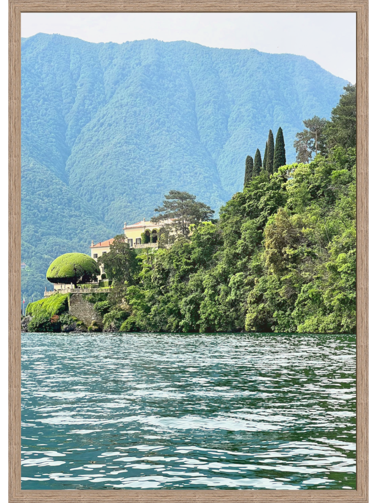 Villa on a hillside with mountains and water in the background
