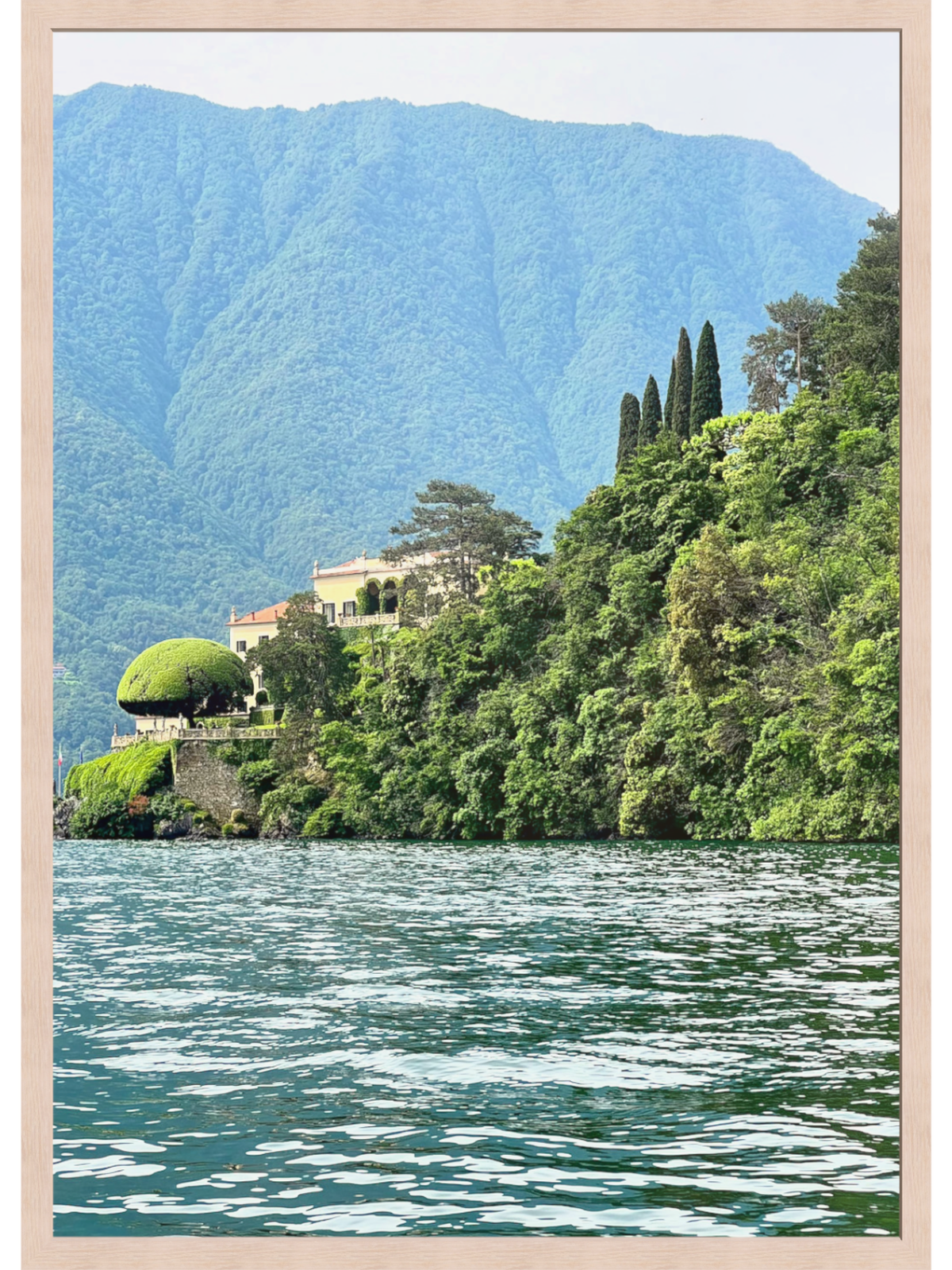 Villa on a hillside overlooking a lake with mountains in the background