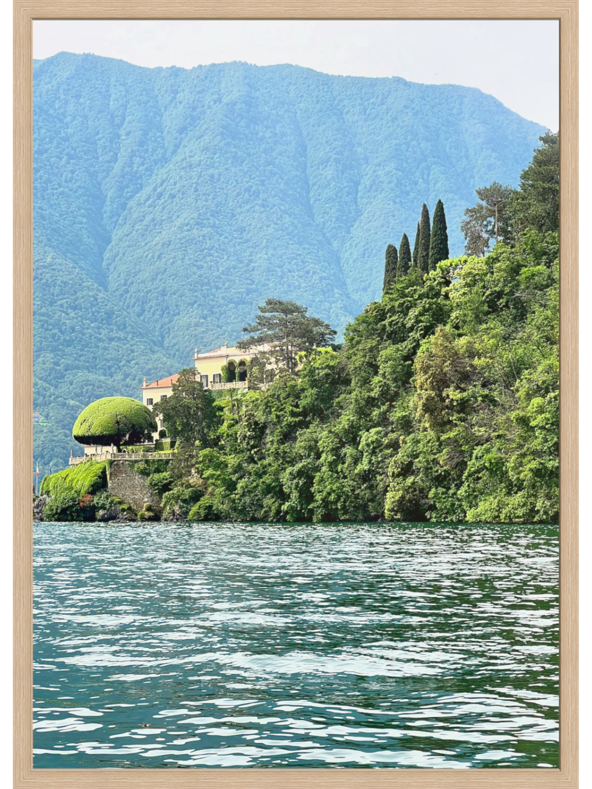 Villa on a hillside overlooking a lake with mountains in the background