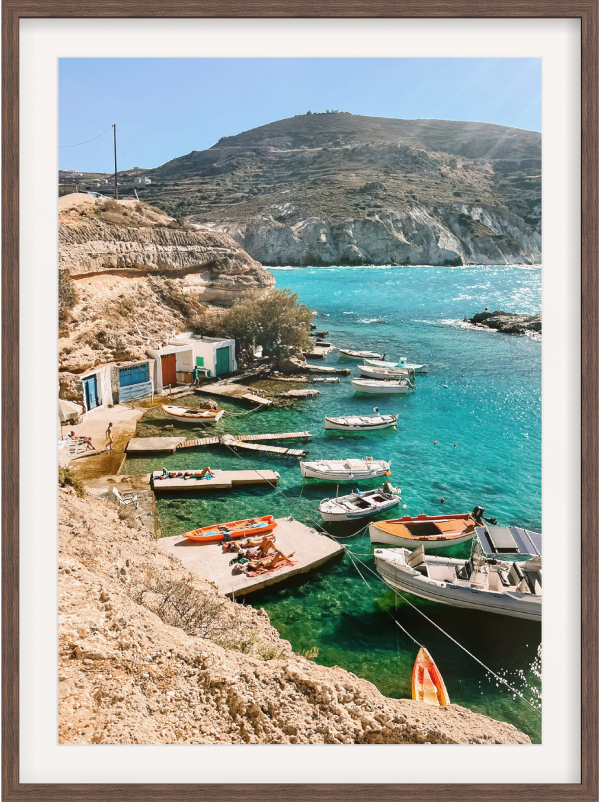 Coastal scene with boats docked near cliffs and turquoise water