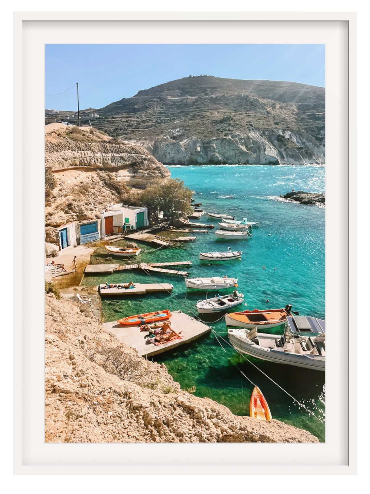 Coastal scene with boats docked near a rocky shore and clear blue water.