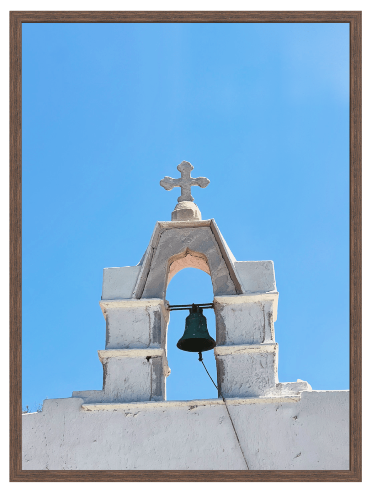 Sunlit Mykonos stone tower details in dark wood frame