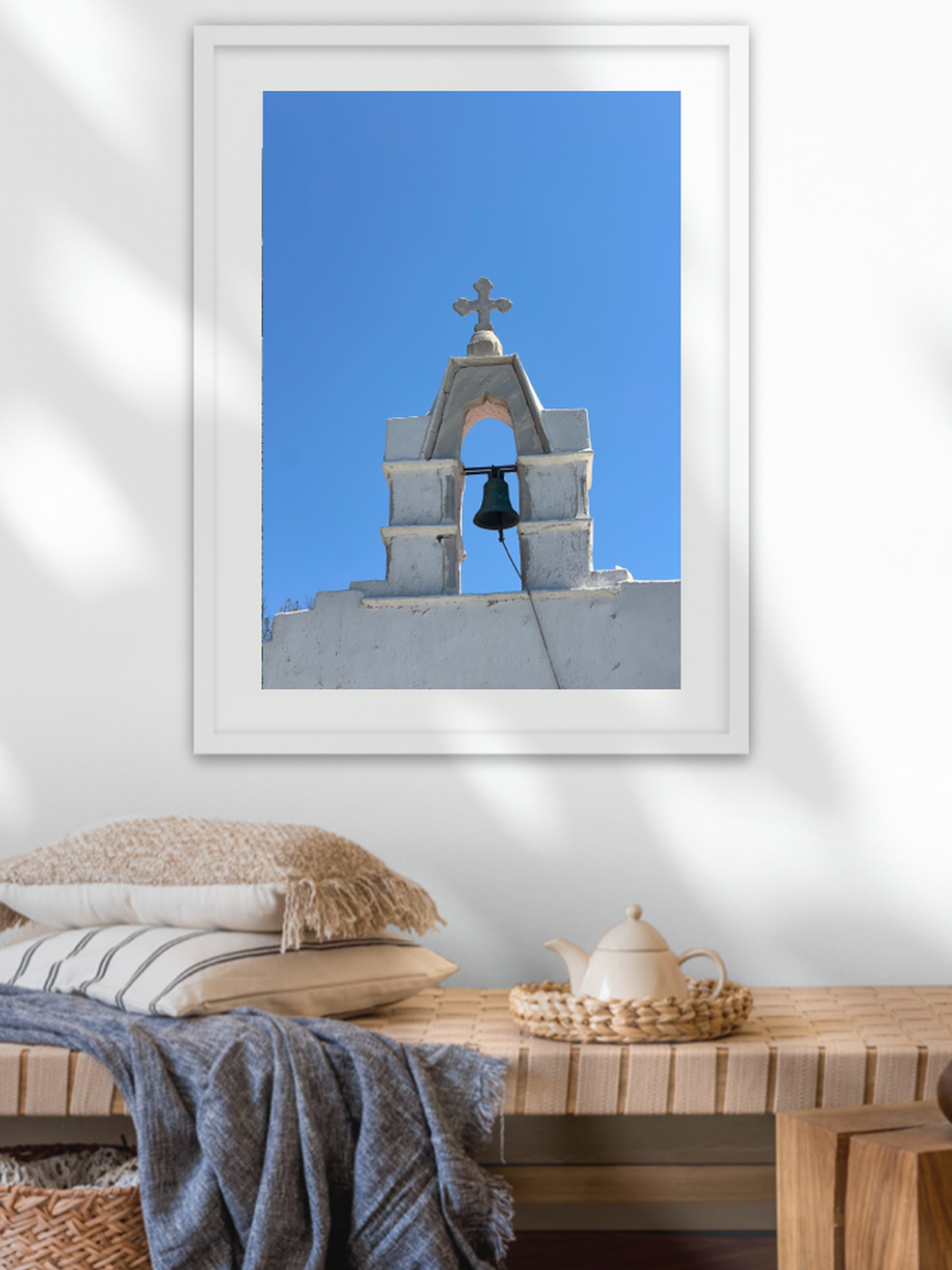 Greek island church print mounted above woven bench decor