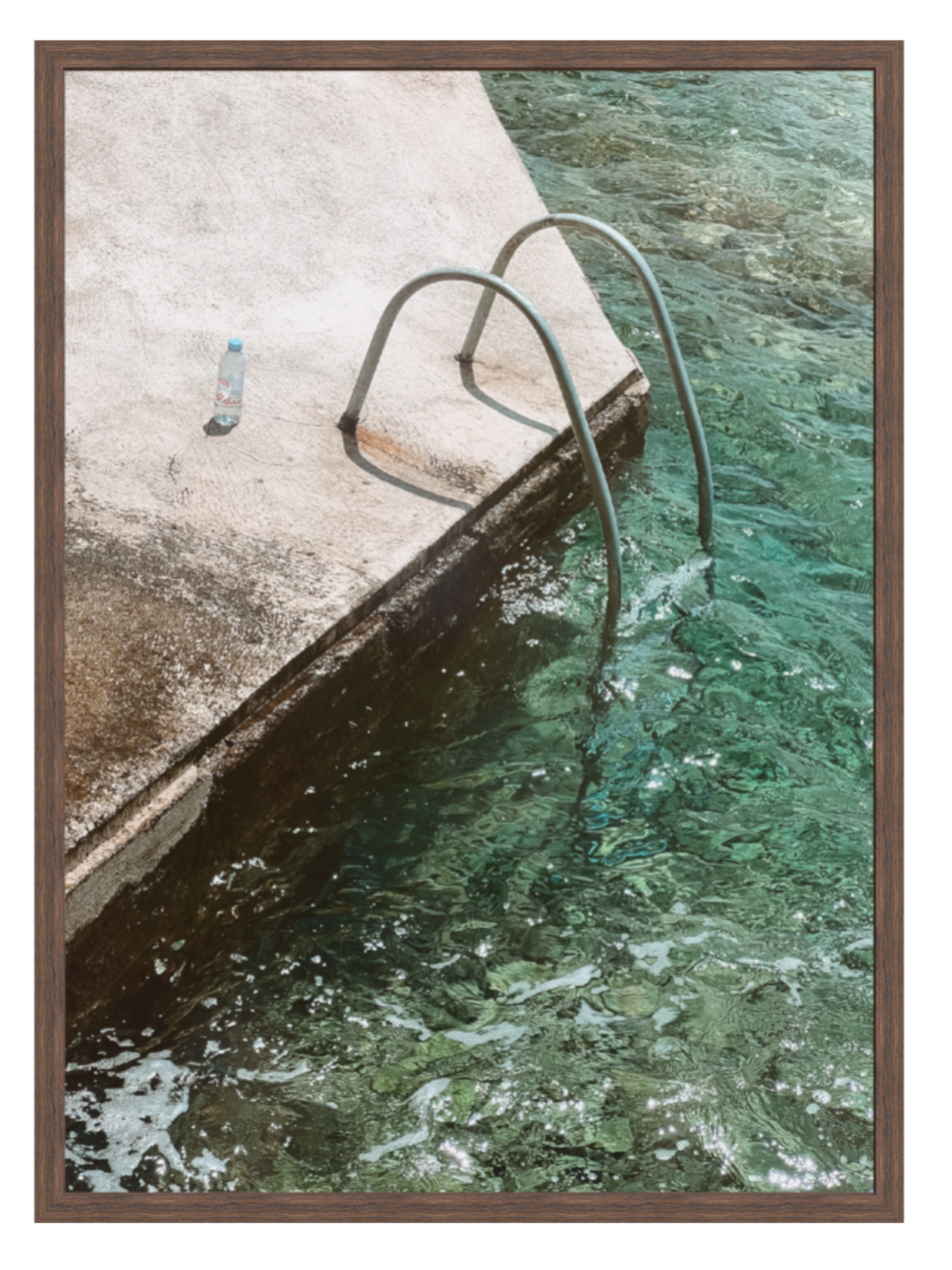 Ladder leading into a pool with clear water next to a concrete platform.