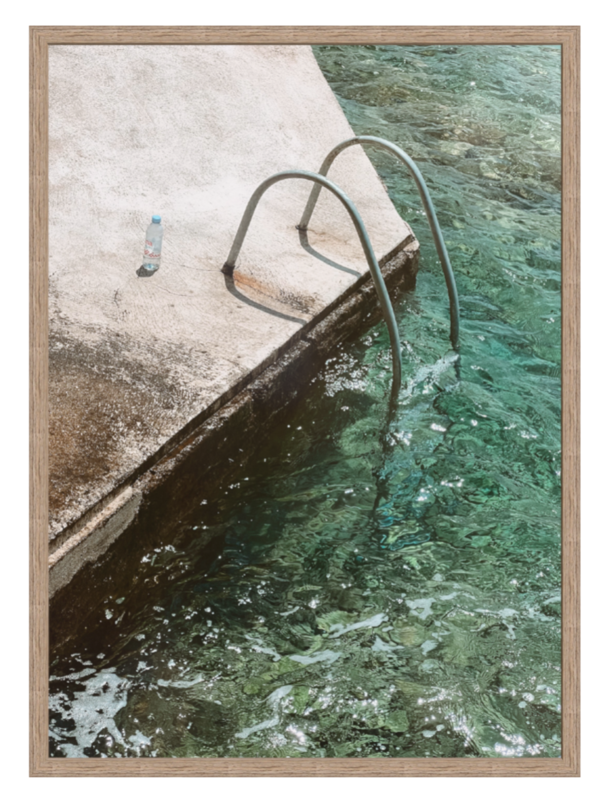 Framed photograph of a pool with a ladder and water edge.