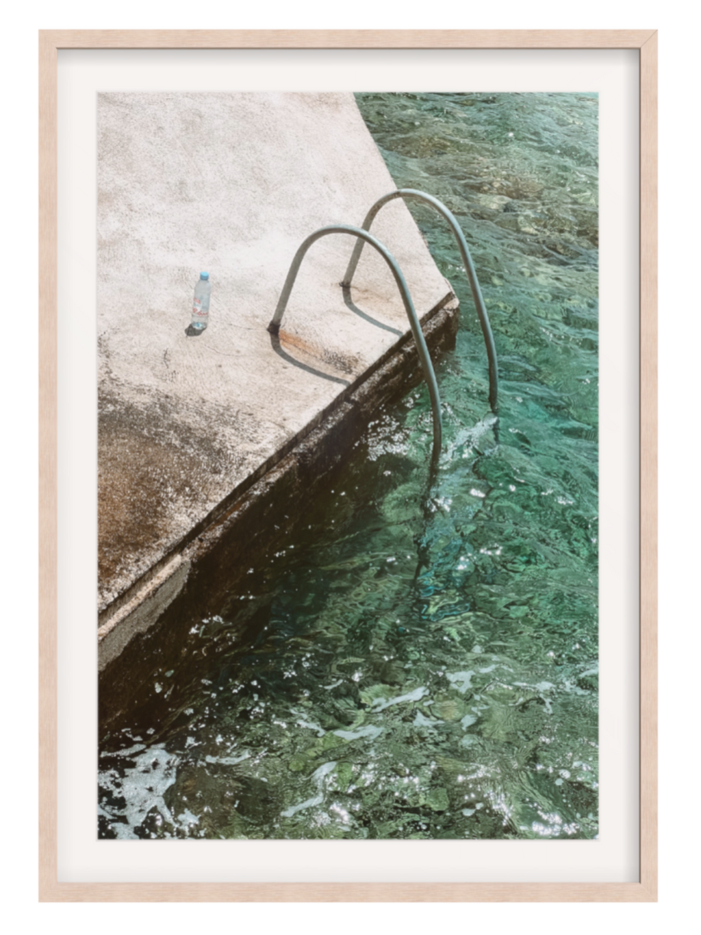 Framed photograph of a pool with a metal ladder and clear water.