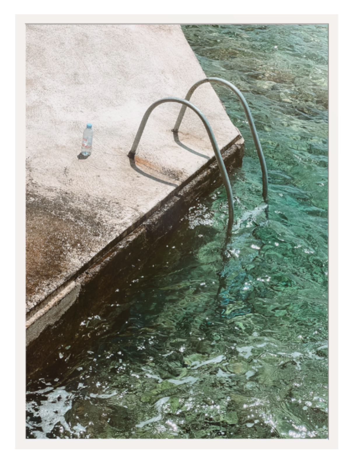 Pool edge with a metal ladder and clear water