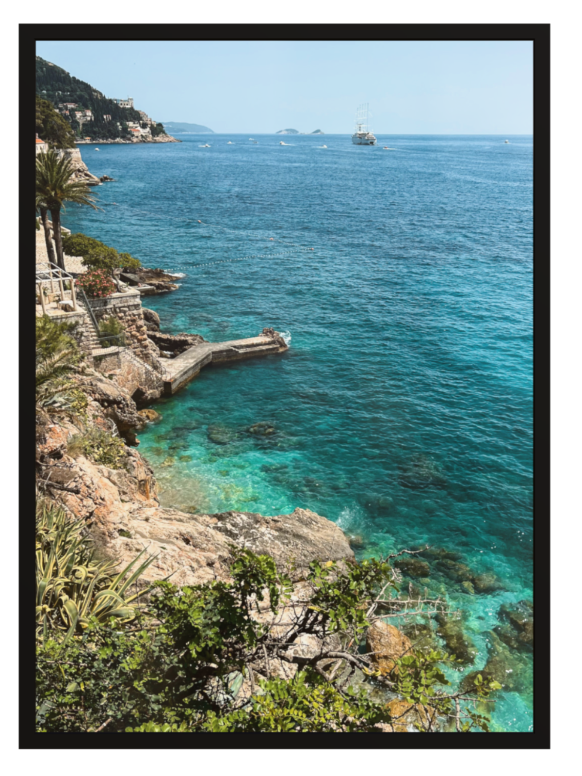 Coastal scene with clear blue water and rocky cliffs.
