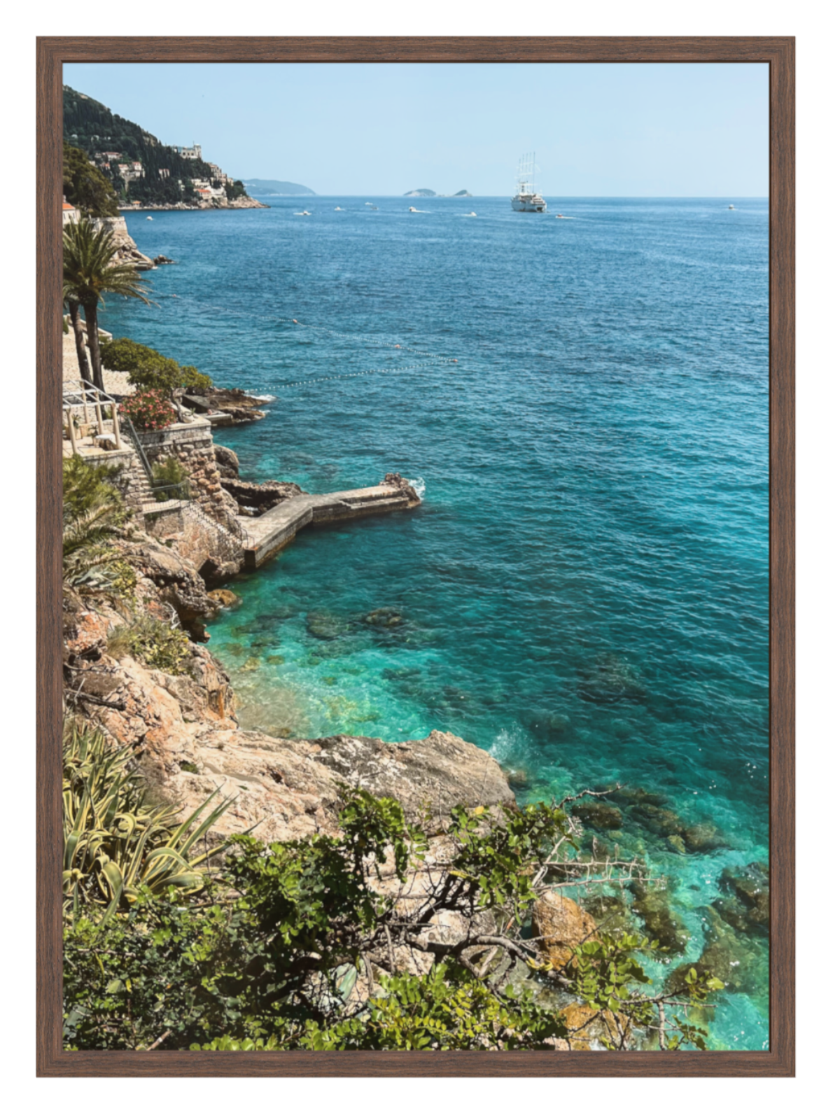 Coastal scene with turquoise waters and rocky cliffs, framed as a photograph.