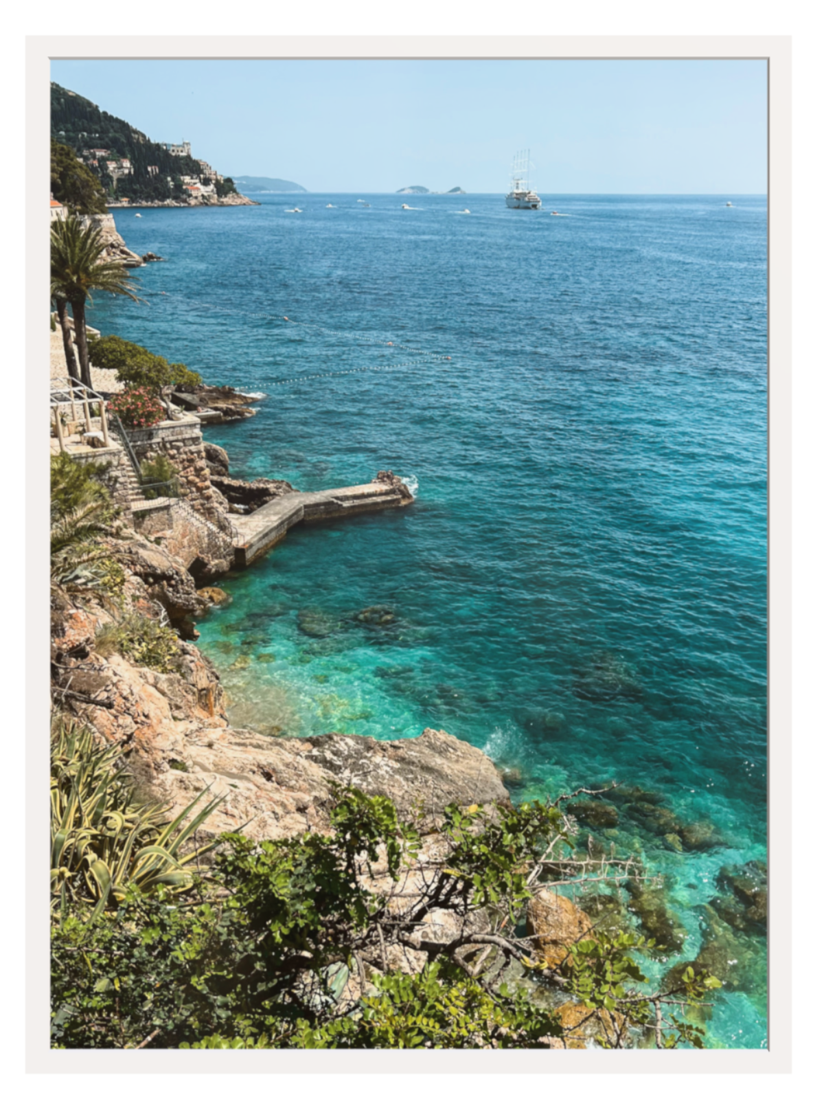Coastal scene with clear blue water and rocky cliffs.