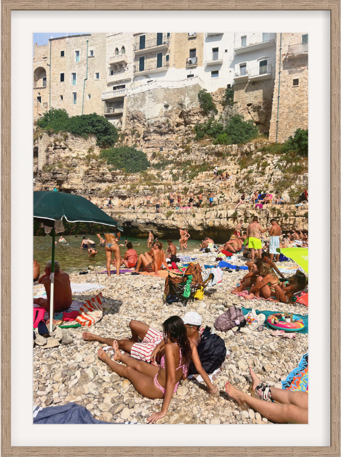 People enjoying a sunny day at a beach with historical buildings in the background