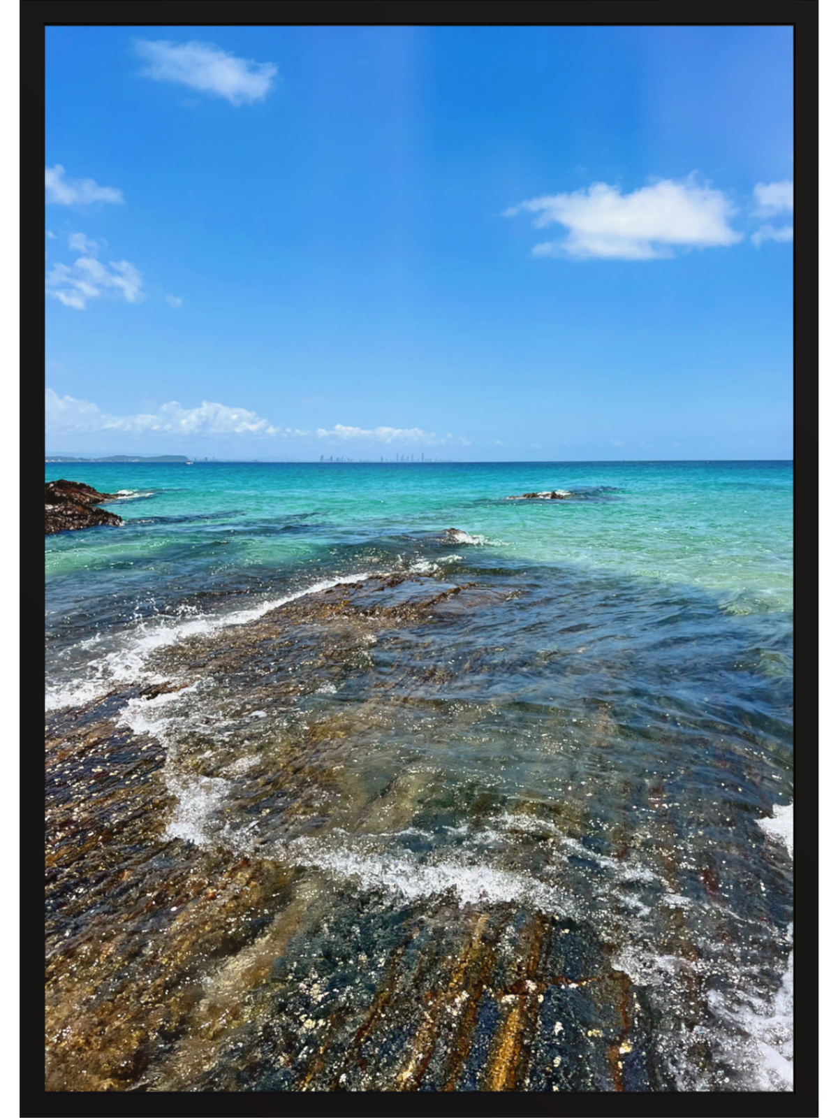 Coastal scene with clear blue water and rocky shoreline.