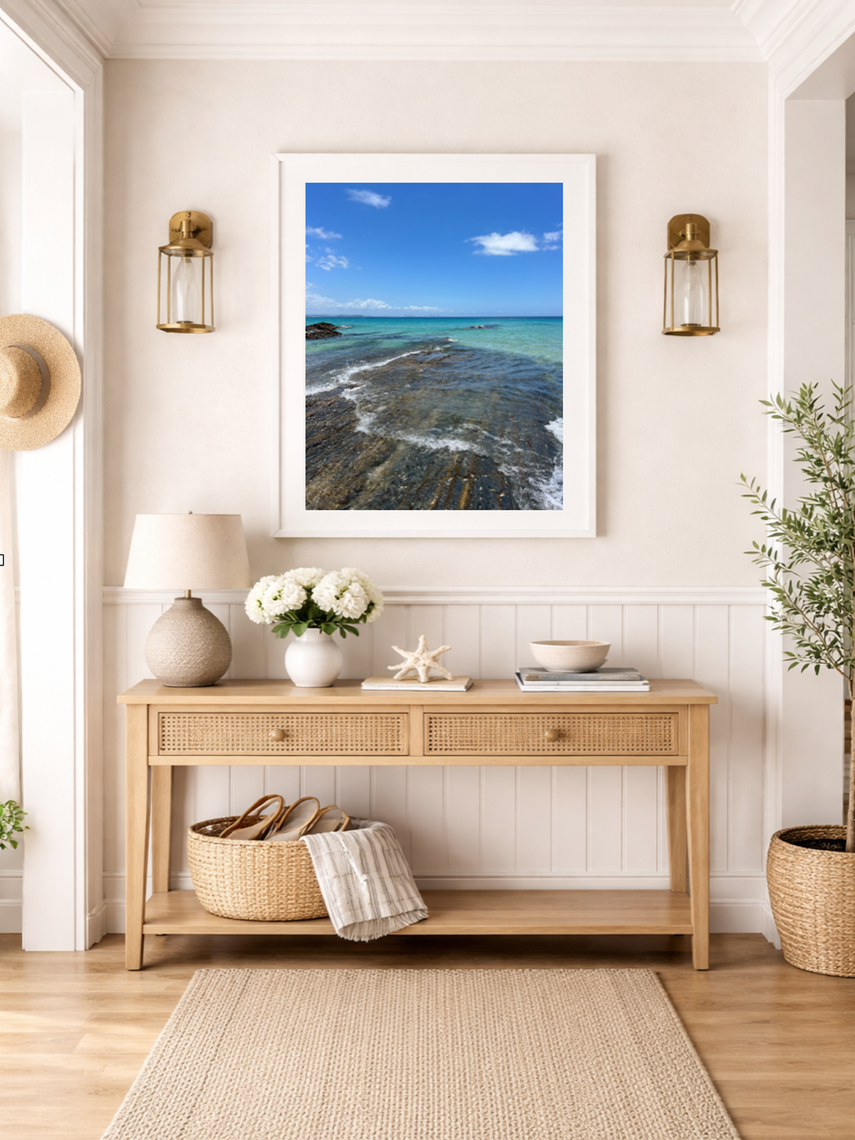 Nautical-themed room with a wooden console table, framed beach photo, and decorative items.