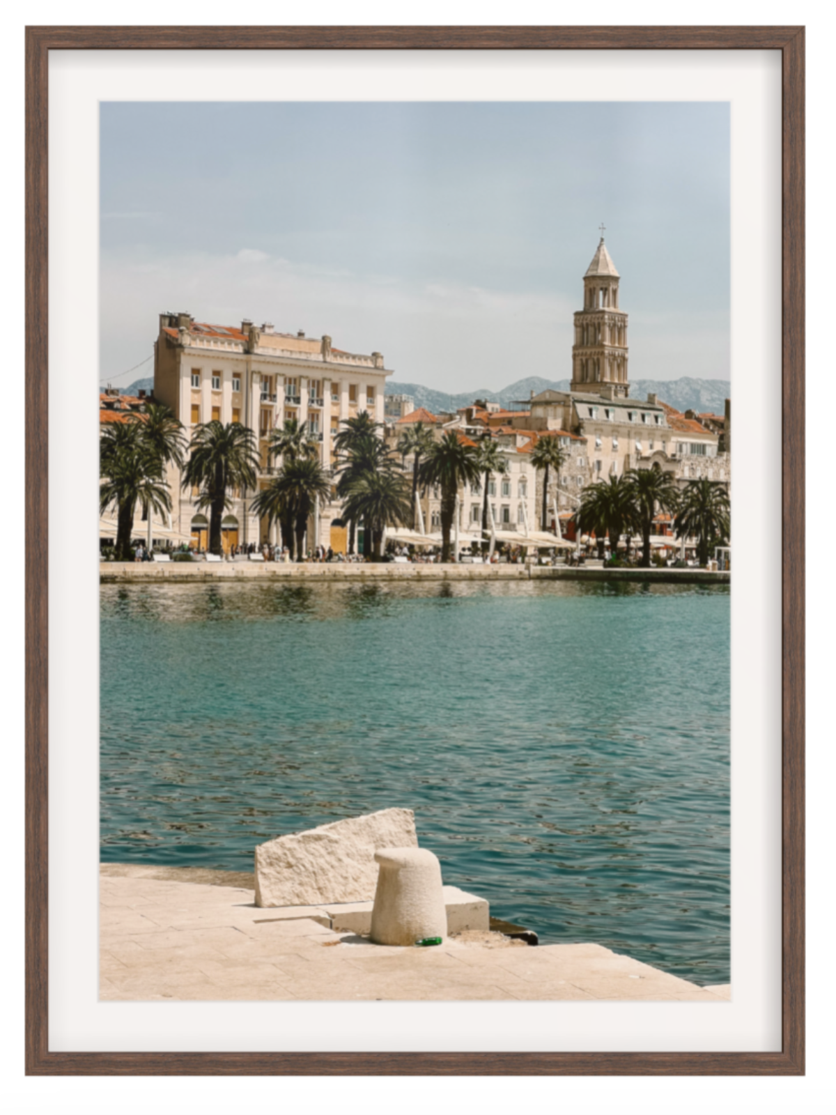 Framed photograph of a coastal cityscape with a clock tower and waterfront. Split chocolate frame with border