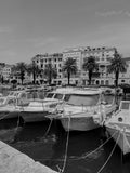 Harbor scene with boats and buildings in a coastal town.