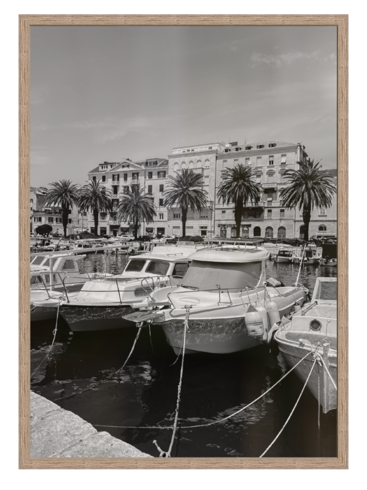 Harbor scene with boats and buildings, framed in a wooden manner.