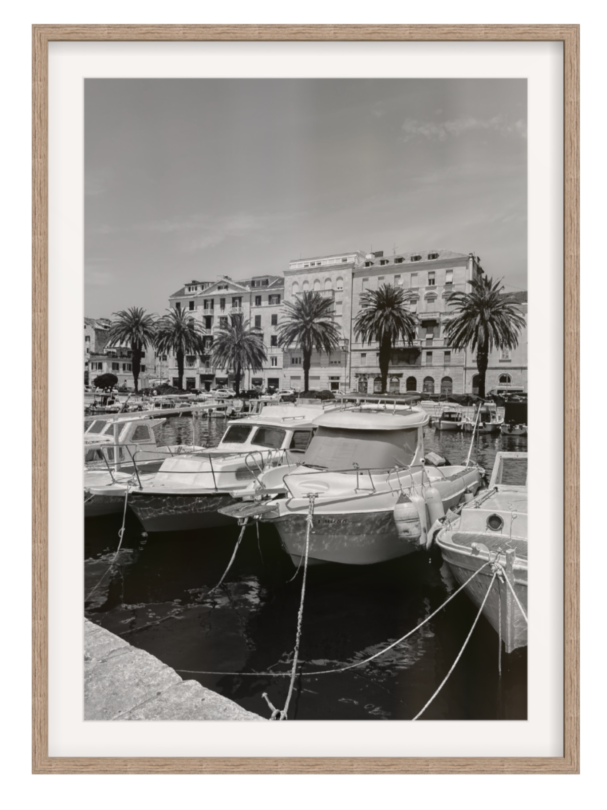 Harbor scene with boats and palm trees, framed in a light wood manner. Split harbour hazel frame with border