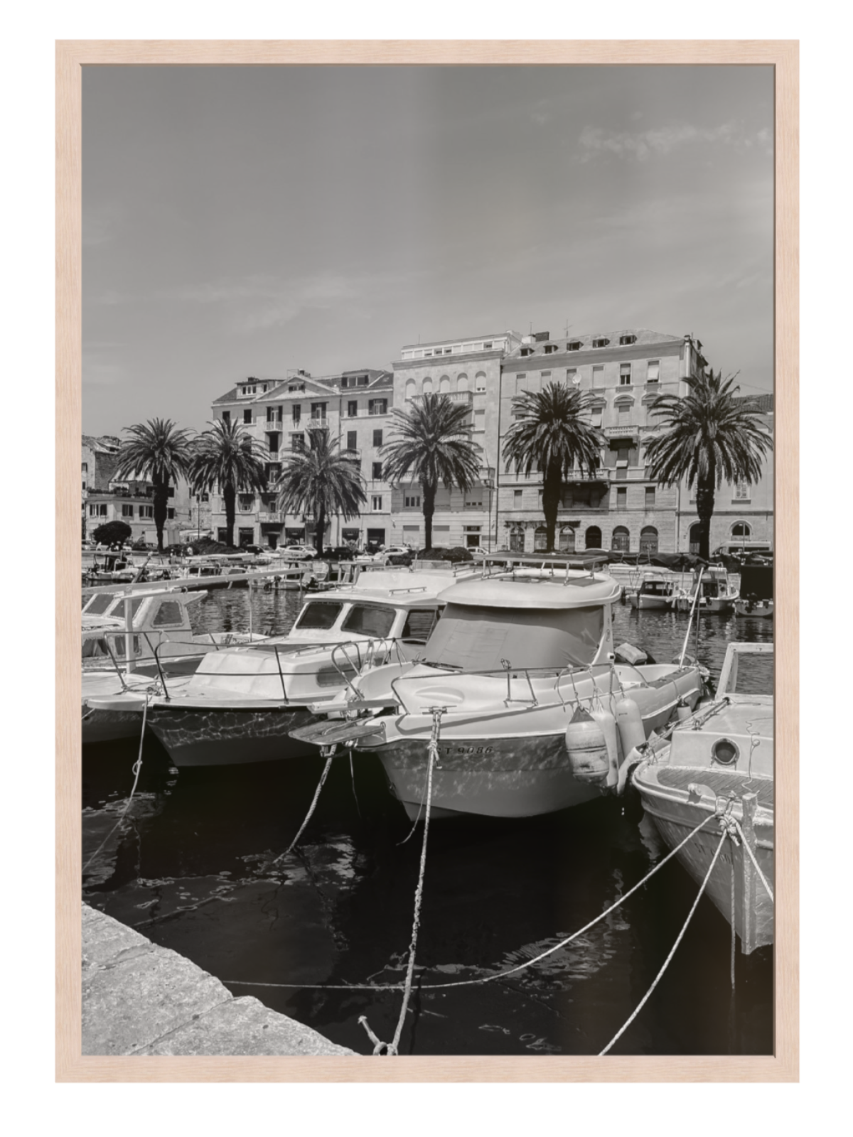 Harbor scene with boats and palm trees in front of a building. Split harbour light oak frame