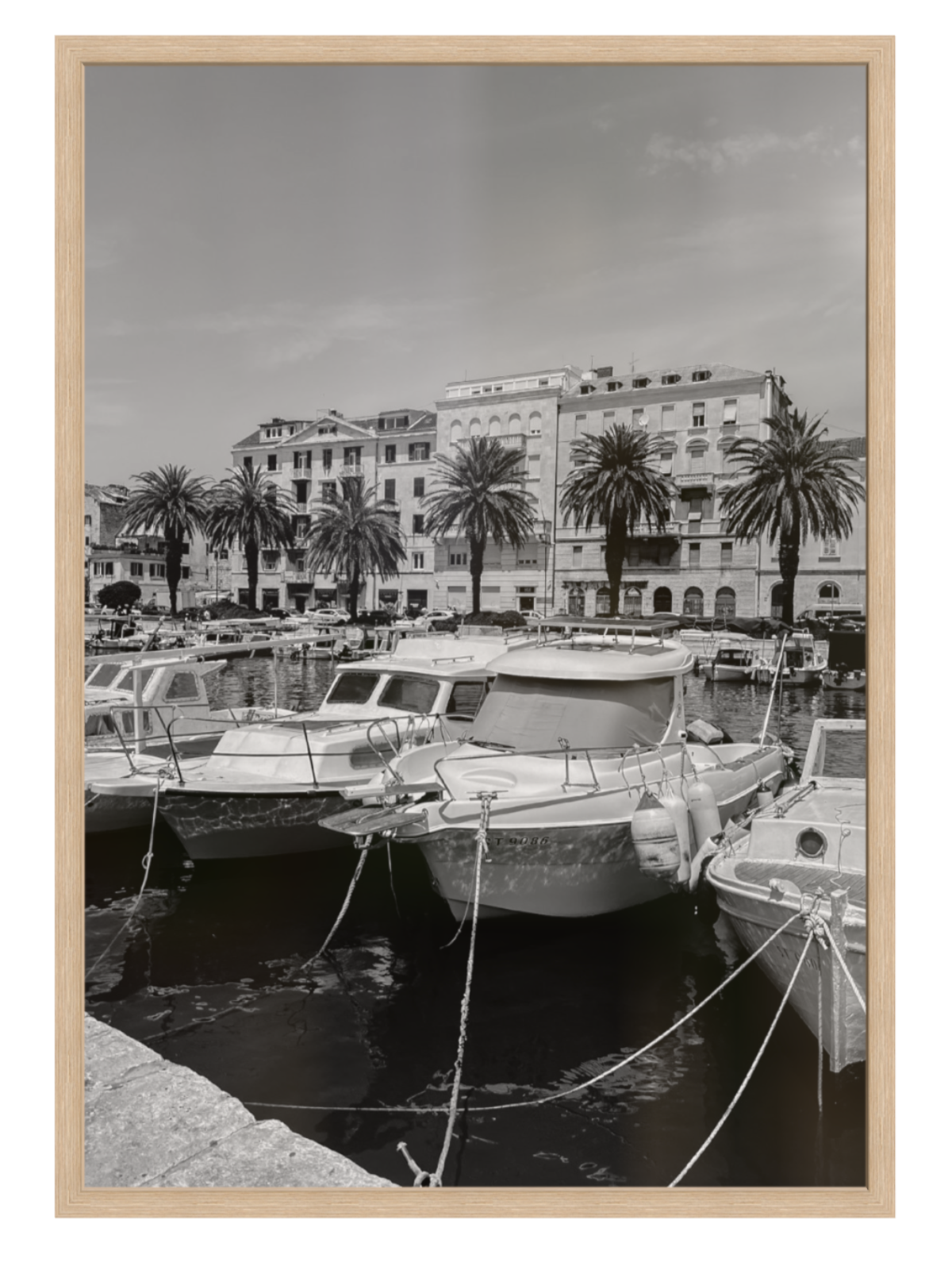 Harbor scene with boats and buildings, framed in a wooden border 