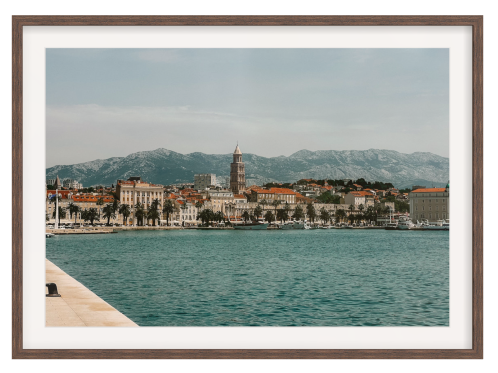 Cityscape with a tower by a body of water, framed as a photograph. Split landscape chocolate frame with border