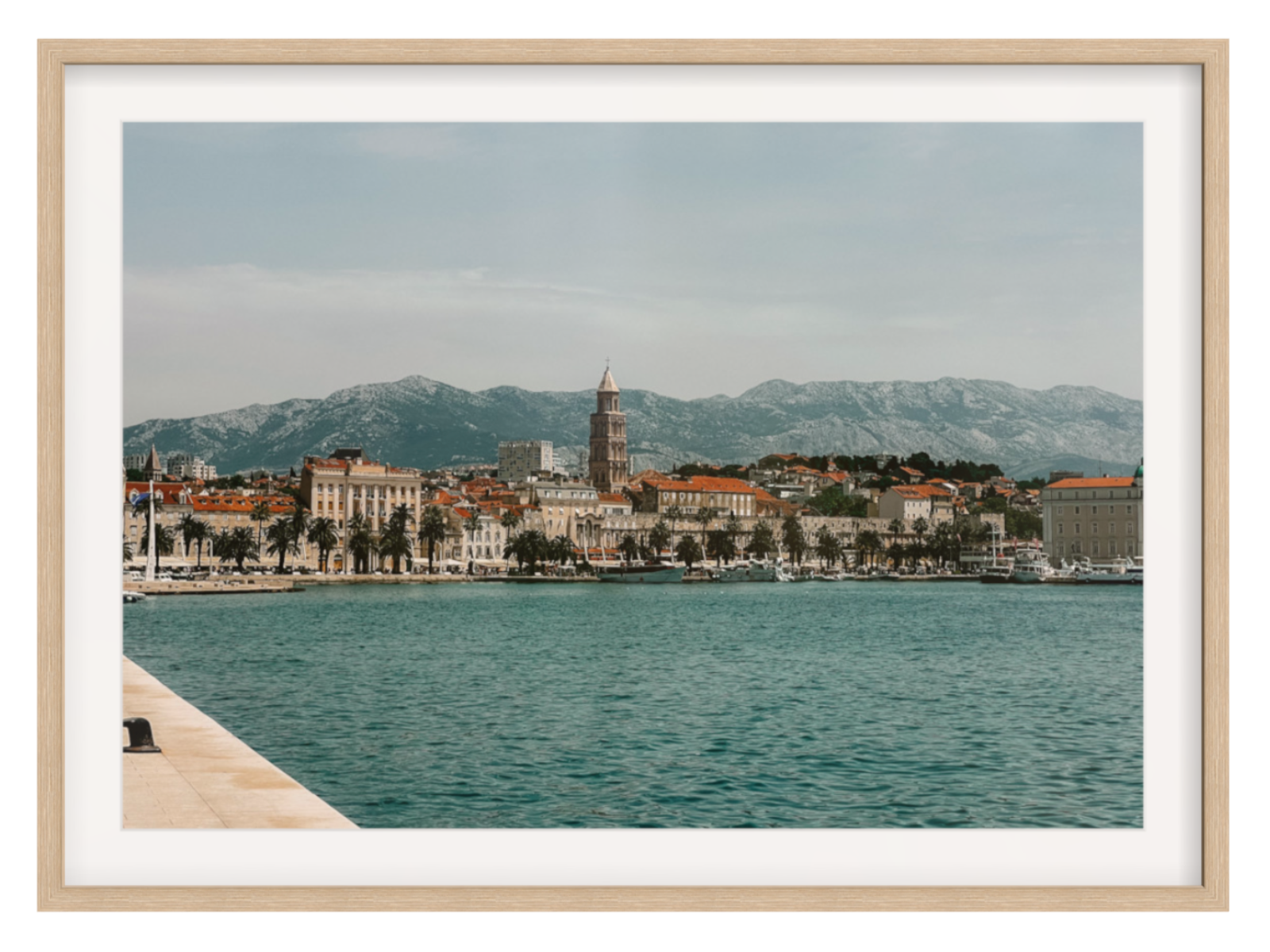 Cityscape with a clock tower by a body of water, framed as a photograph. Split landscape oak frame with border