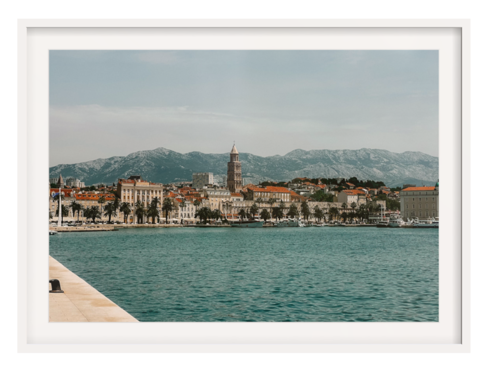 Cityscape with waterfront and mountains in the background. Split landscape white frame with border